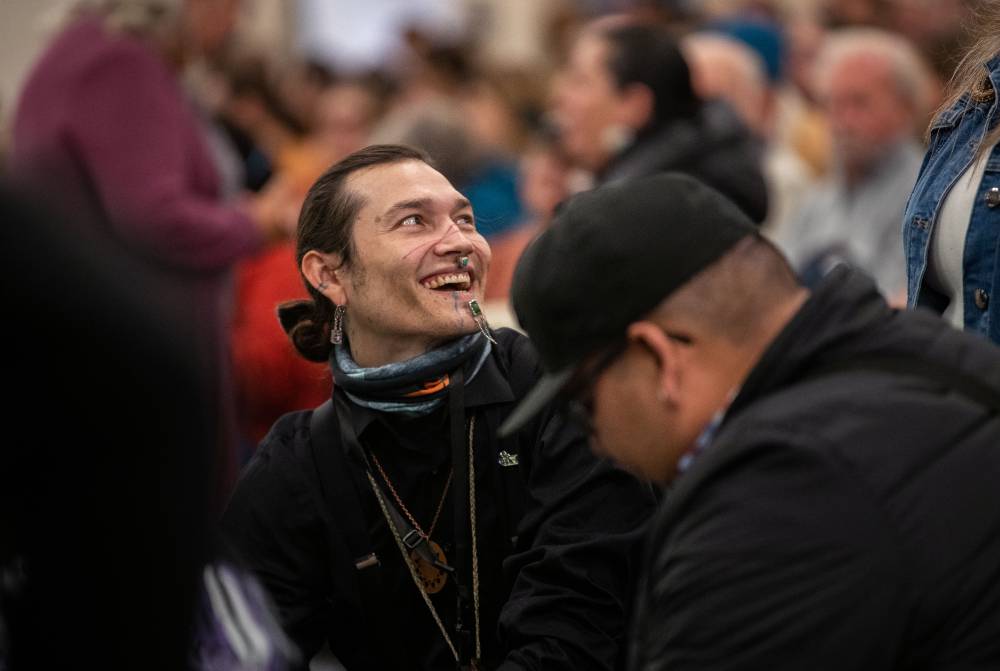 A member of Wandering Nation drum group smiling as they prepare for the event to begin